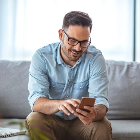 Man,With,Spectacles,Relaxing,Sitting,On,Couch,While,Looking,At